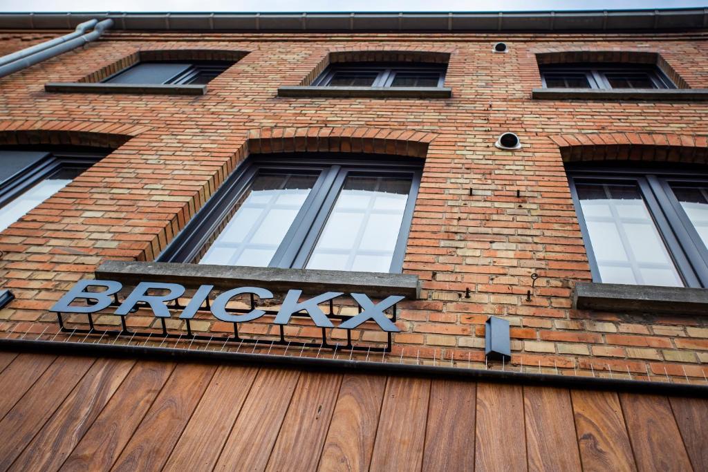 un edificio de ladrillo con un letrero de repollo. en Vakantiehuis Brickx en Koksijde