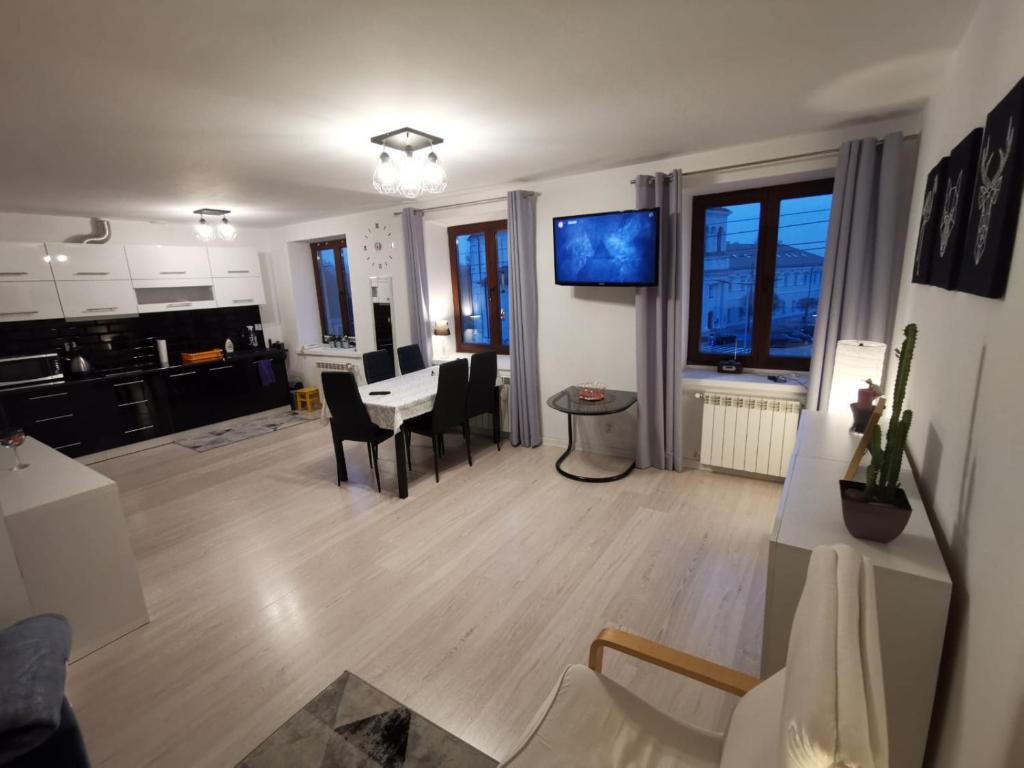 eine Küche und ein Wohnzimmer mit einem Tisch und Stühlen in der Unterkunft Apartament w centrum Rawy Mazowieckiej in Rawa Mazowiecka