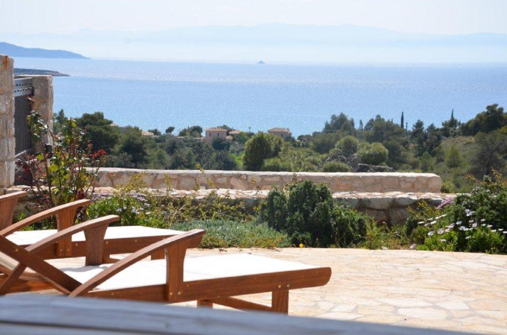 d'une terrasse avec deux chaises en bois et une vue sur l'océan. dans l'établissement Cozy vacation home, à Porto Heli