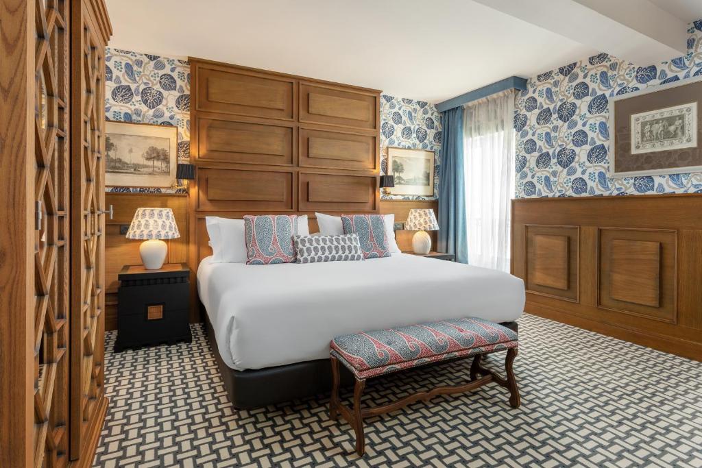 a bedroom with a large bed and blue and white wallpaper at Room Mate Collection Alba, Madrid in Madrid