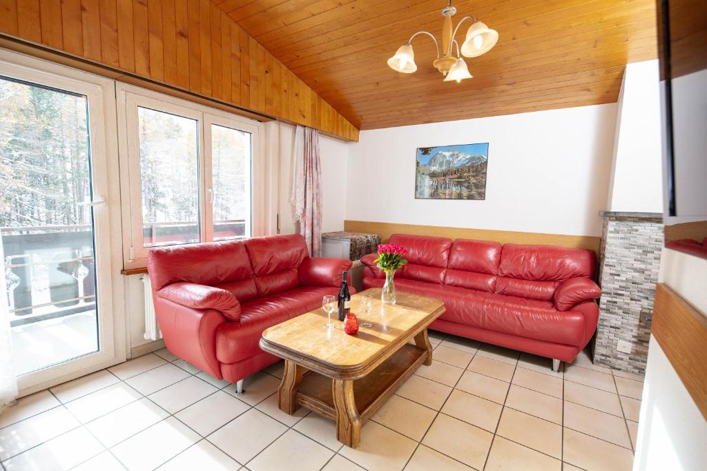 a living room with a red couch and a table at Haus Alfa in Saas-Fee