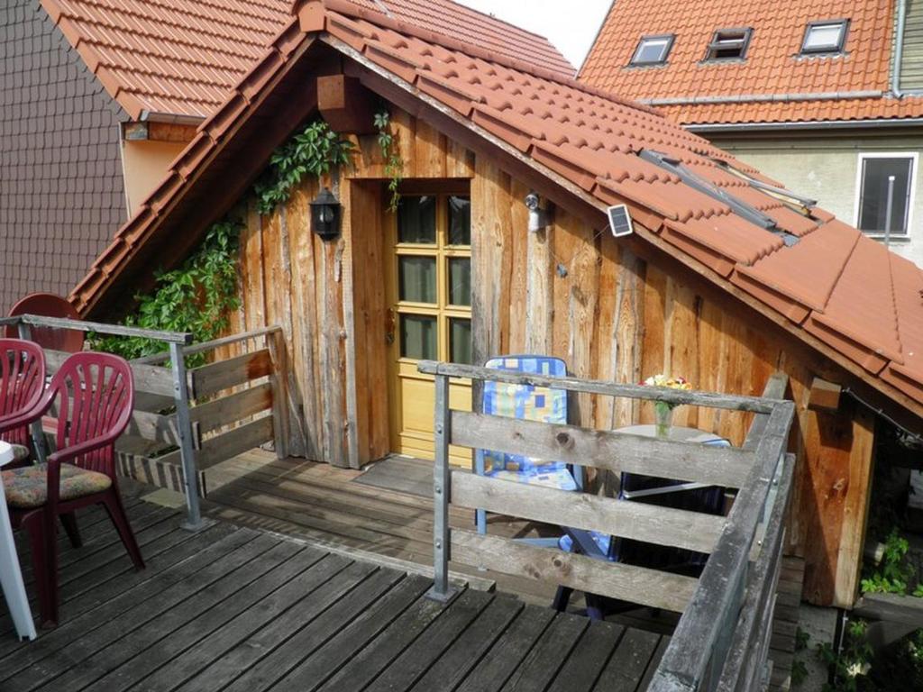 a wooden deck with a building with a roof at Ferienwohnungen Michel in Weimar