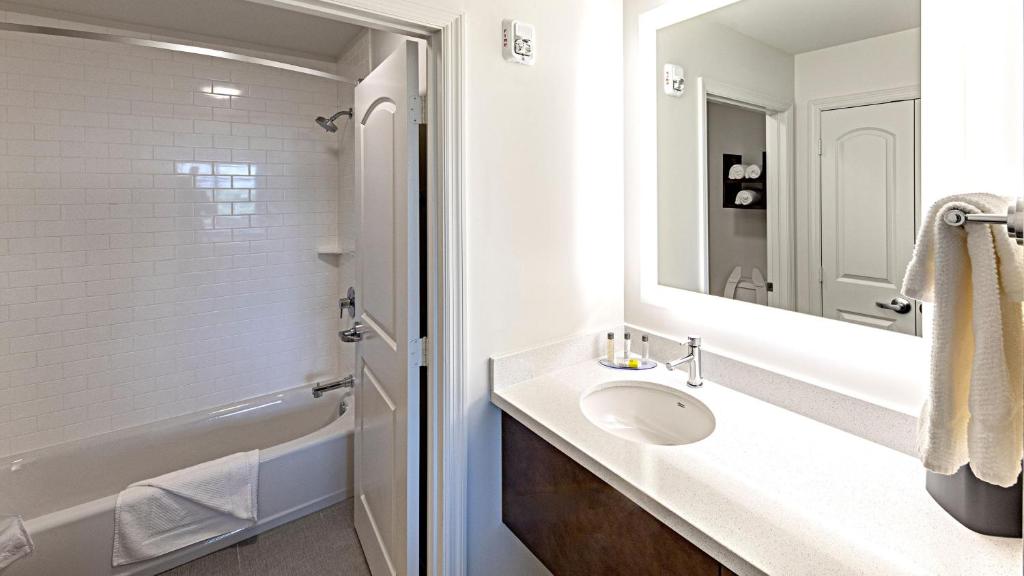 a white bathroom with a sink and a mirror at Staybridge Suites - Naples - Marco Island by IHG in Naples