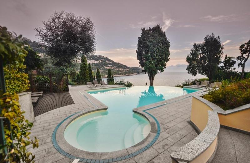a large swimming pool with a view of the water at Diodato Suite Apartment - Amazing Location, WiFi, Pool, Sauna, Gym & Private Garden in Roquebrune-Cap-Martin