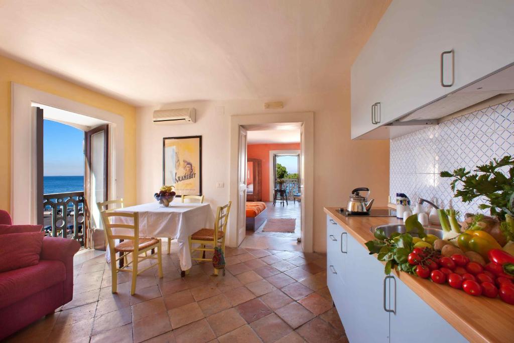 a kitchen and dining room with a table with a view of the ocean at Maison Alice in Sorrento