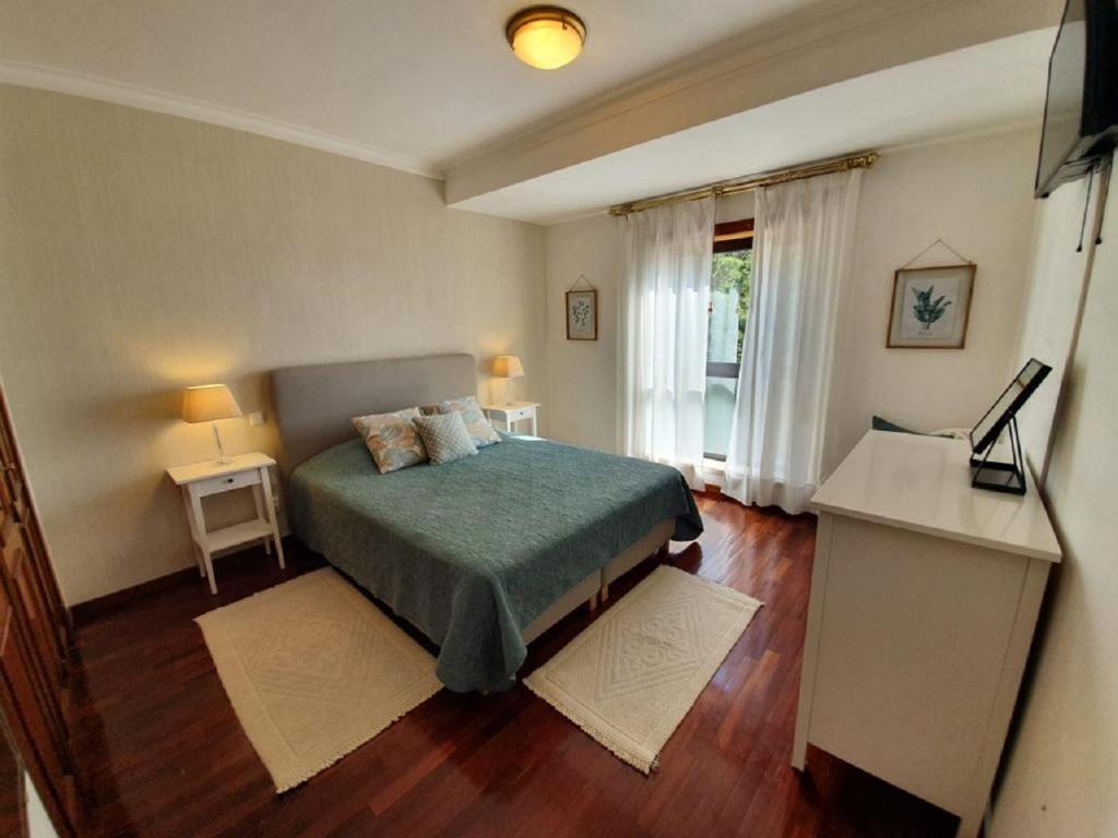 een slaapkamer met een bed, een bureau en een raam bij Apartment Afonso Henriques in Coimbra