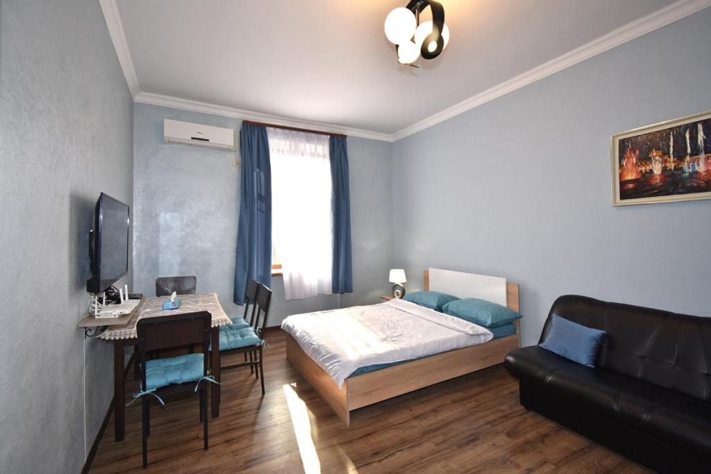 a bedroom with a bed and a table and a desk at Apartment near Sasundci Davit Metro Station in Yerevan