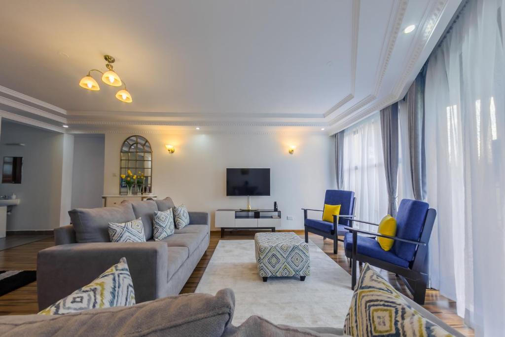 a living room with a couch and a tv at Edmor Residences Riverside in Nairobi