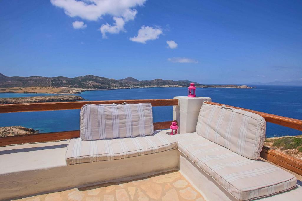two chairs on a balcony with a view of the ocean at Antiparos Vibes in Agios Georgios