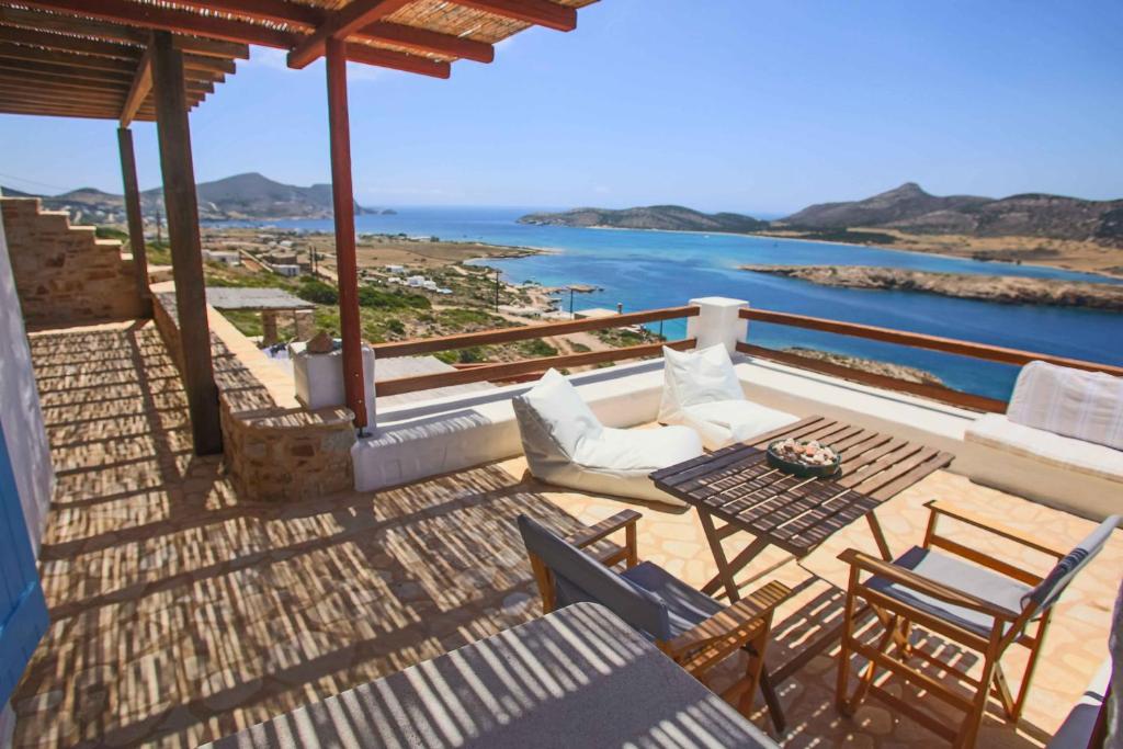 a balcony with a table and chairs and the ocean at Antiparos Vibes in Agios Georgios