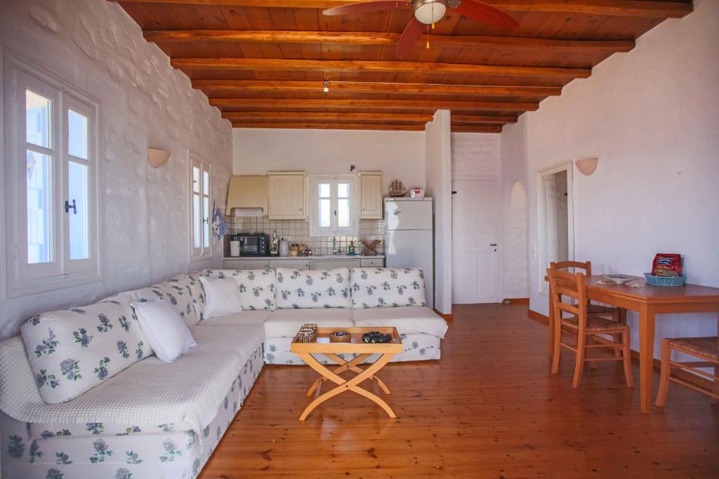 a living room with a white couch and a table at Antiparos Vibes in Agios Georgios