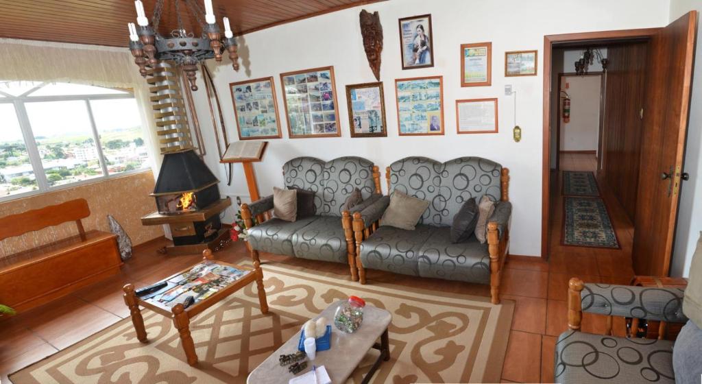 sala de estar con sofá y mesa en Pousada Colina Da Neve, en São Joaquim