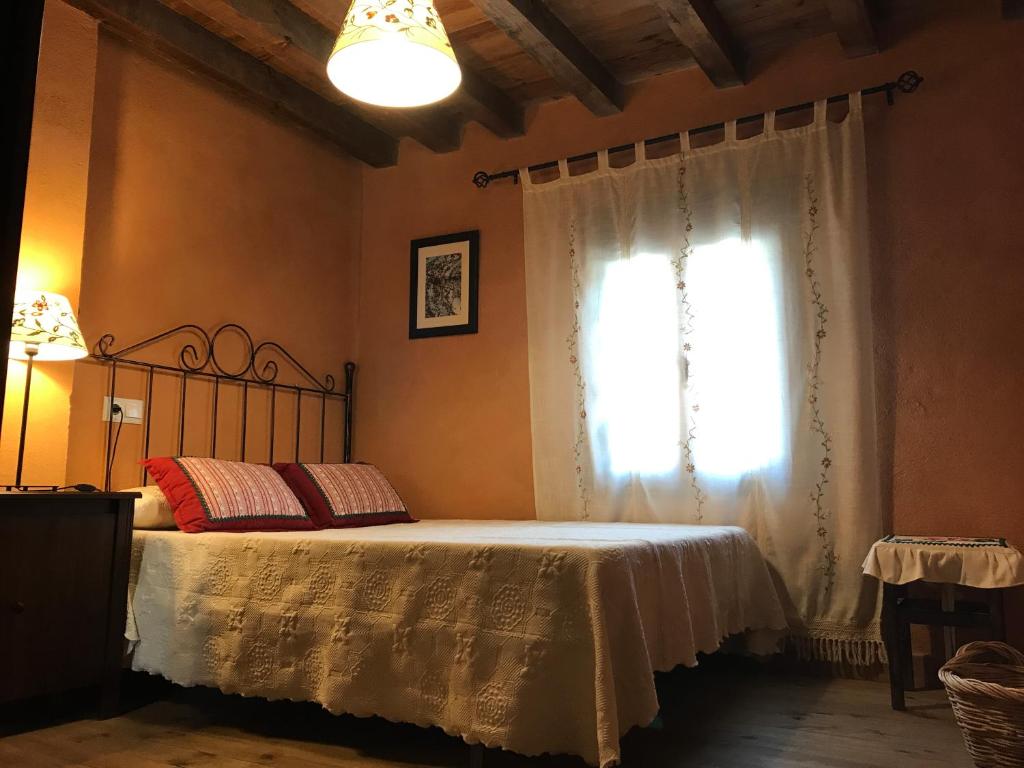 een slaapkamer met een bed en een raam bij Casa rural La Piedrapipa in Madrigal de la Vera