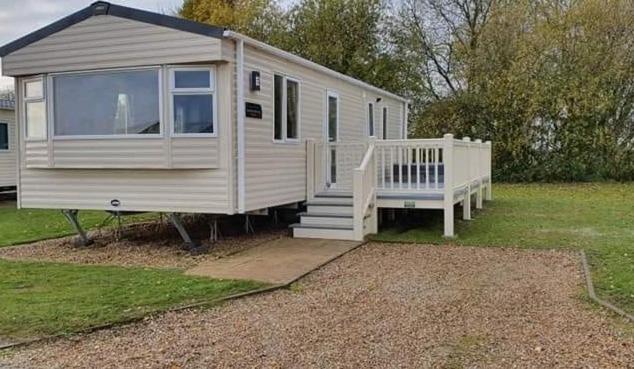 a white tiny house with a porch and a staircase at KSR Hot Tub Holiday Home at Tattershall Lakes in Tattershall