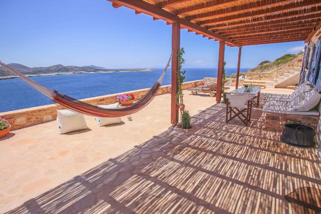 a hammock on a patio with a view of the ocean at Antiparos Vibes in Agios Georgios