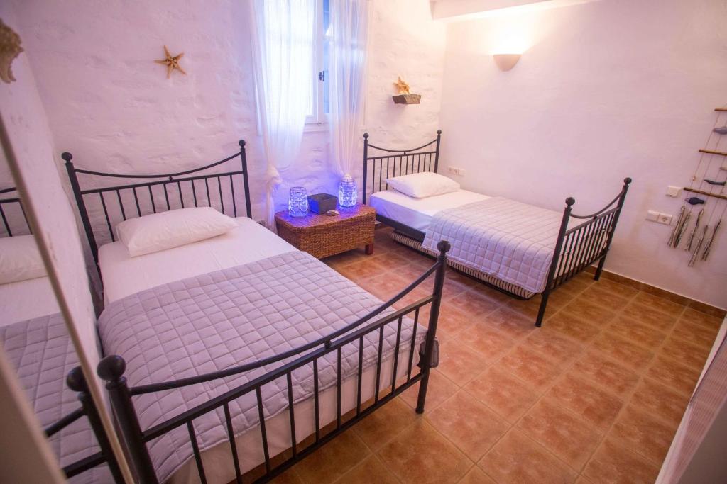 two twin beds in a room with at Antiparos Vibes in Agios Georgios