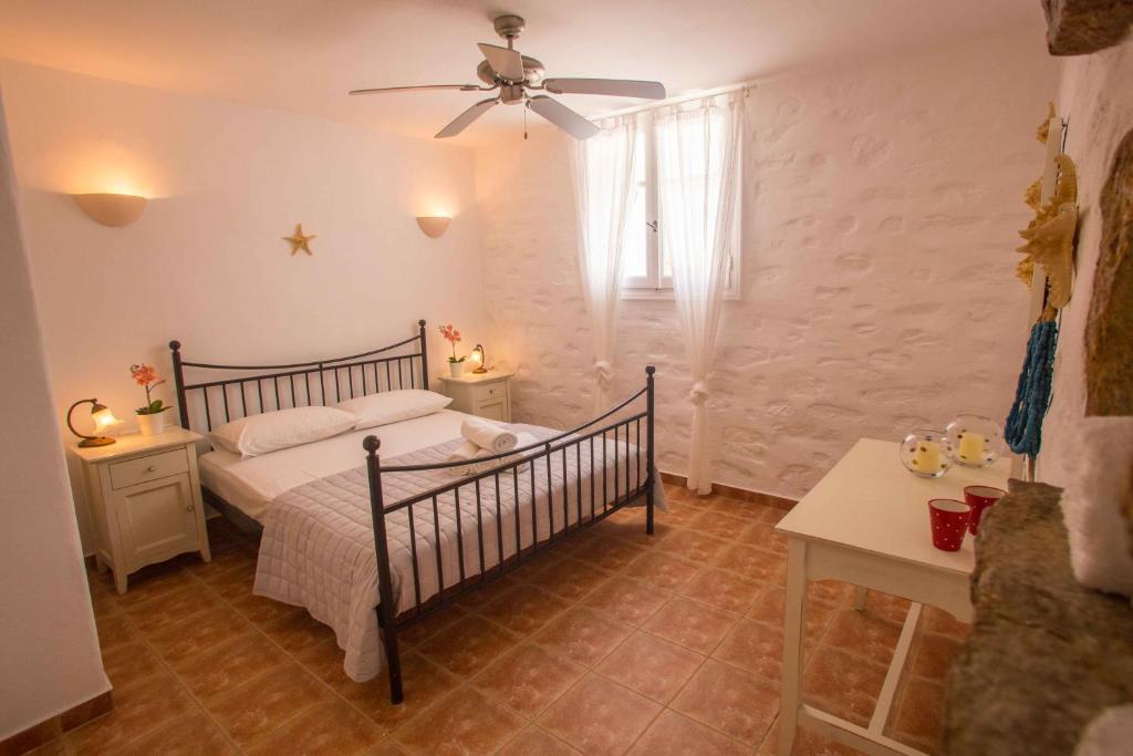 a bedroom with a bed and a ceiling fan at Antiparos Vibes in Agios Georgios