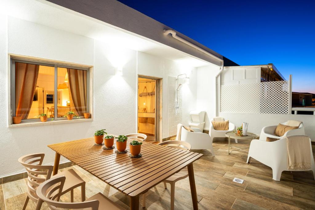 a dining room with a wooden table and chairs at Baixa de Faro Rooftop in Faro