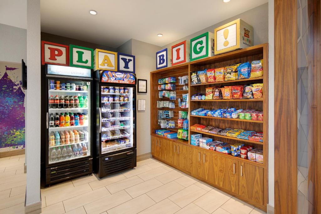 a grocery store aisle with two refrigerators and food at Holiday Inn Express & Suites S Lake Buena Vista by IHG in Kissimmee