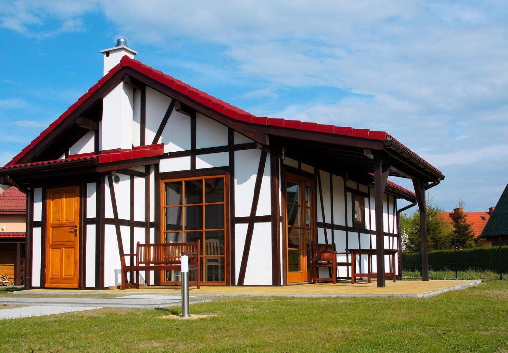 una piccola casa con tetto rosso e bianco di 4 Domki a Sarbinowo