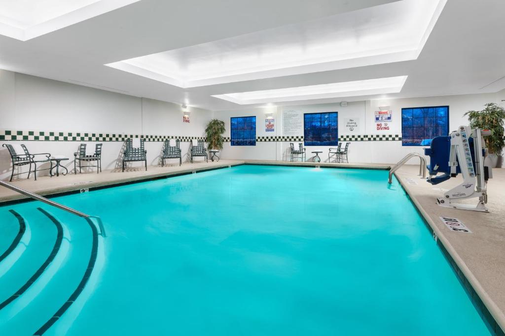 a pool with blue water in a large room at Holiday Inn & Suites Raleigh Cary, an IHG Hotel in Cary