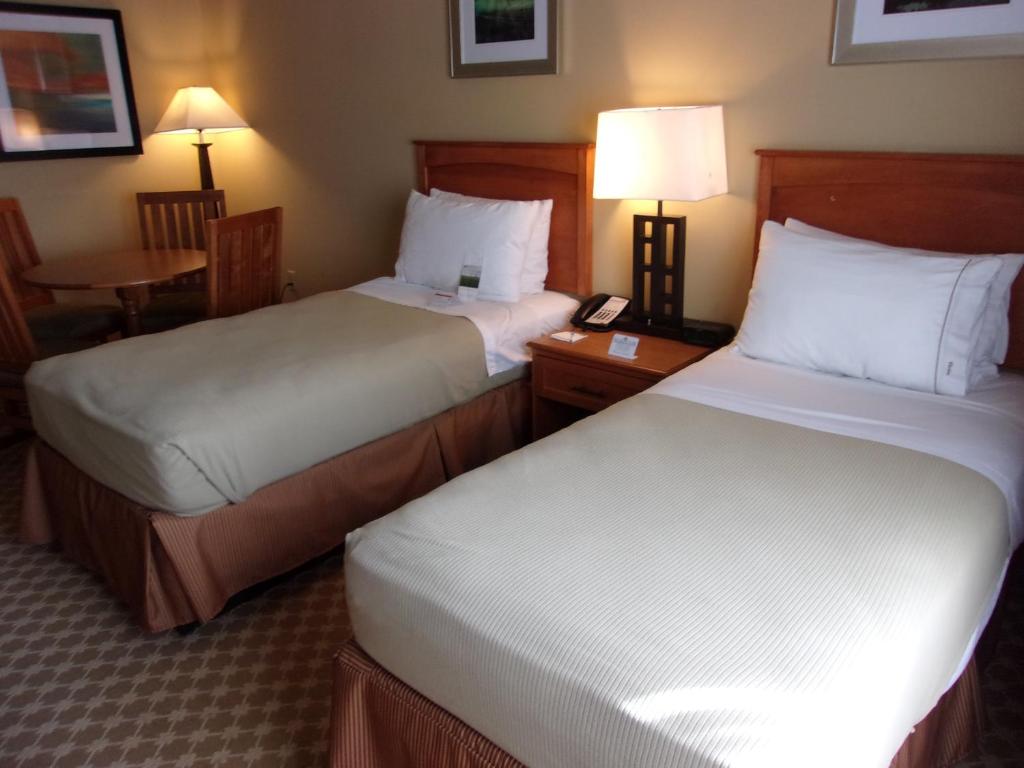 a hotel room with two beds and a telephone at Holiday Inn Express Hotel & Suites Chicago West Roselle, an IHG Hotel in Roselle