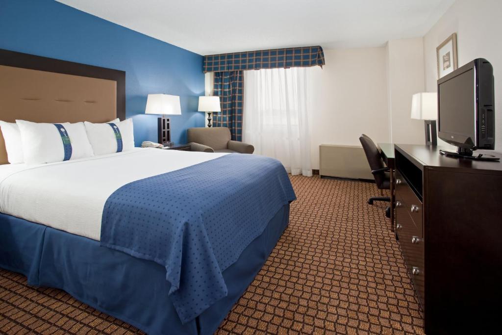 Een bed of bedden in een kamer bij Ramada Plaza by Wyndham Sheridan Hotel & Convention Center