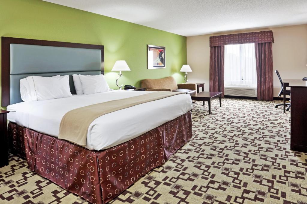 ein Hotelzimmer mit einem großen Bett und einem Schreibtisch in der Unterkunft Holiday Inn Express Troutville-Roanoke North, an IHG Hotel in Troutville