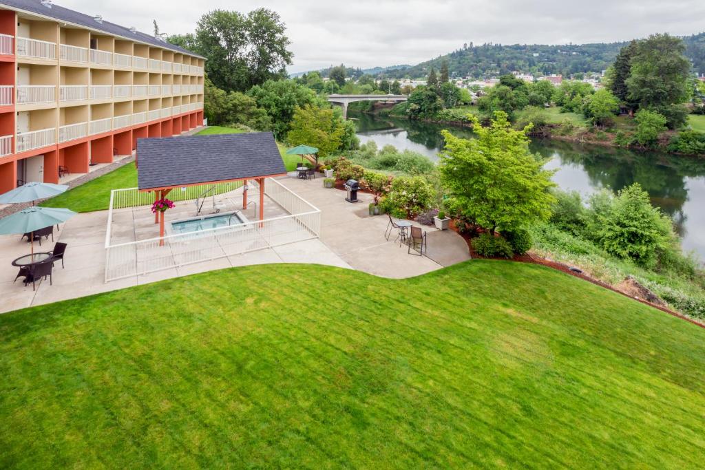 an aerial view of a building with a lawn and a river at Holiday Inn Express Roseburg, an IHG Hotel in Roseburg