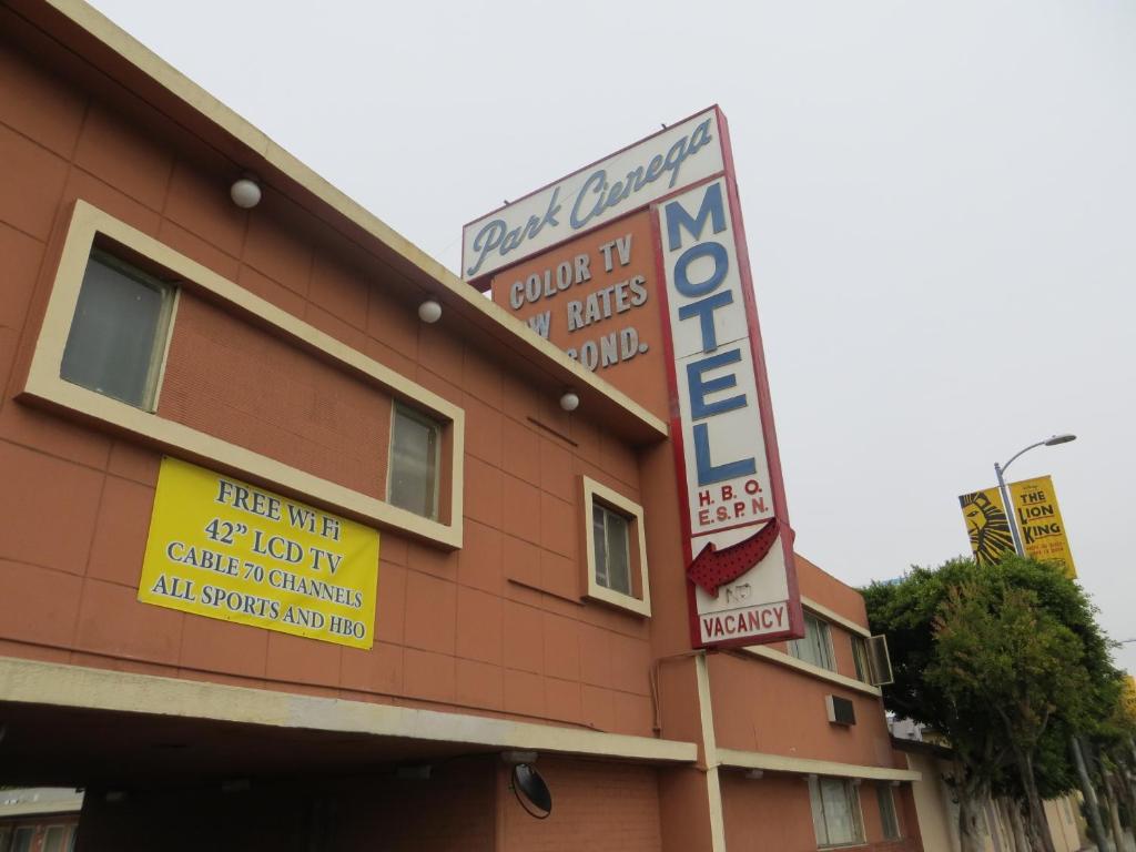 un edificio con letreros en el costado en Park Cienega Motel, en Los Ángeles