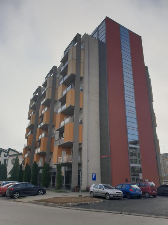 a large building with cars parked in a parking lot at Central Residence in Deva