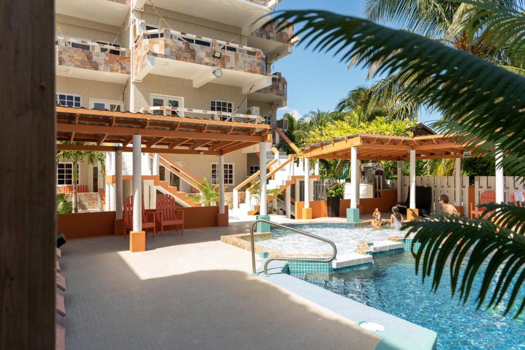 a resort with a swimming pool and a building at Island Magic Beach Resort in Caye Caulker