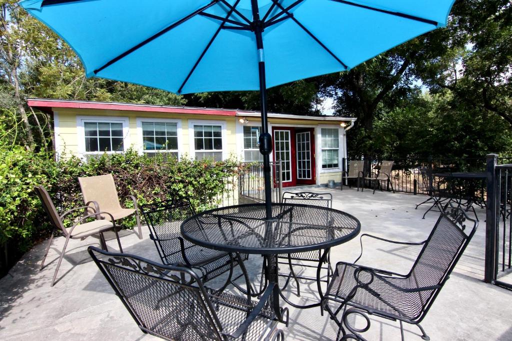 een tafel en stoelen met een blauwe parasol op een patio bij Cabin on the Hill in Third Crossing