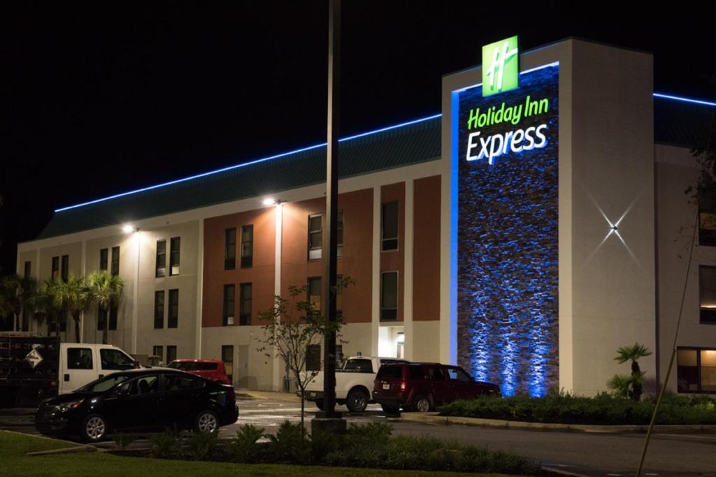 un edificio con un letrero iluminado en un estacionamiento en Holiday Inn Express Pascagoula-Moss Point, an IHG Hotel, en Moss Point