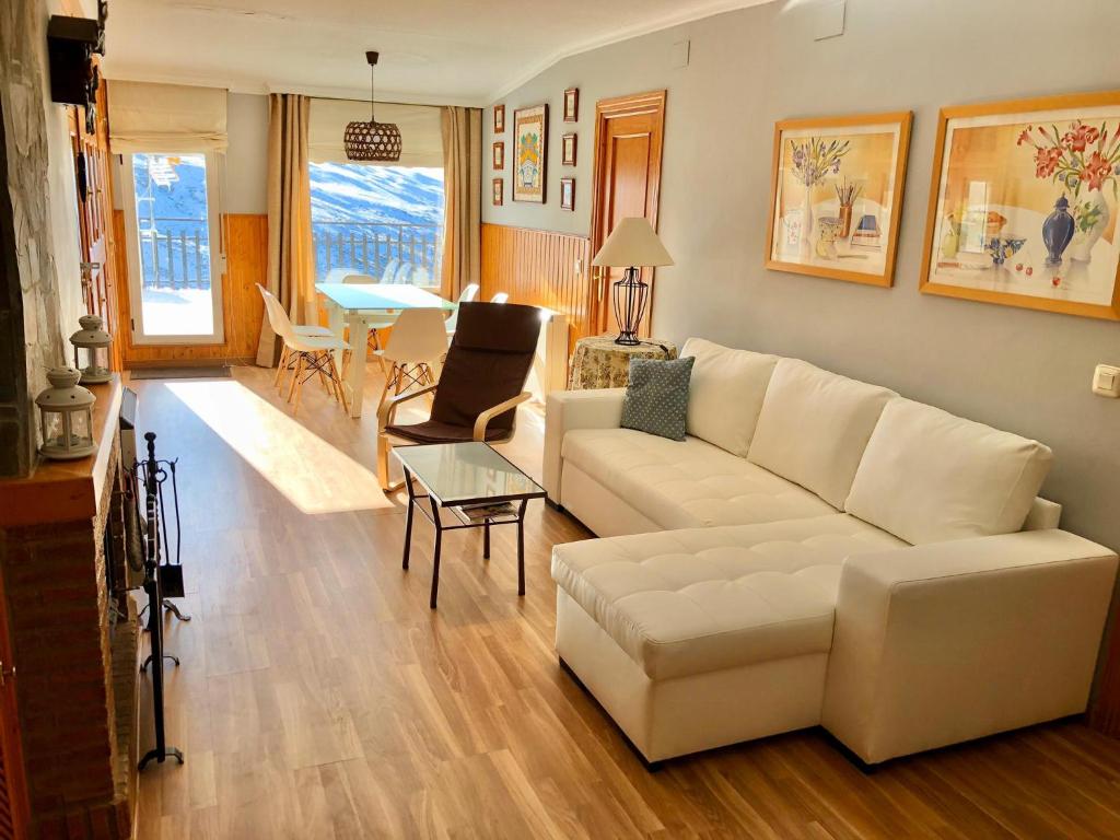 een woonkamer met een witte bank en een tafel bij LUXURY GINEBRA in Sierra Nevada