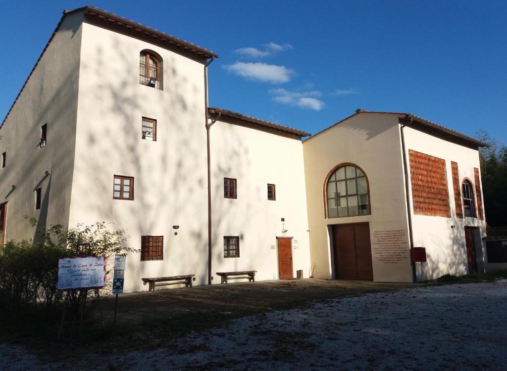 een wit gebouw met een bank ervoor bij Casa di Zela in Olmi