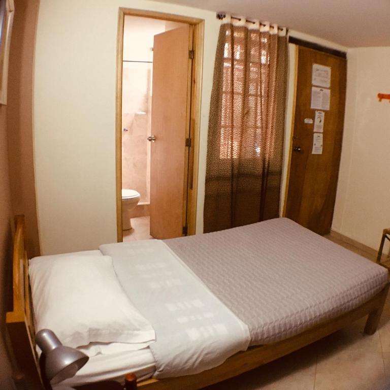 Postel nebo postele na pokoji v ubytování Hostal La Candelaria