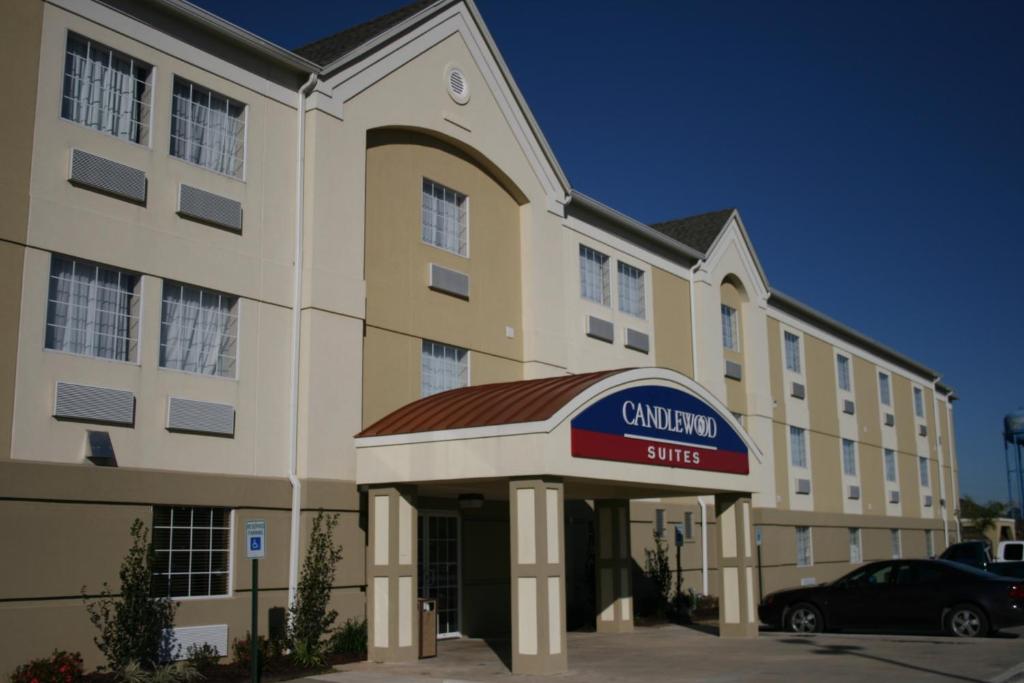 Candlewood Suites Lake Charles-Sulphur, an IHG Hotel في سولفور: مبنى مع لافتة فندق كامبريا في موقف للسيارات