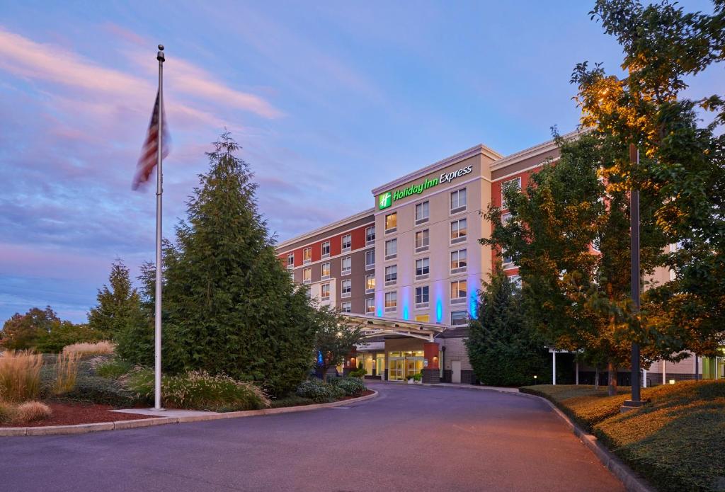 a hotel building with a flag on a street at Holiday Inn Express : Eugene - Springfield by IHG in Springfield