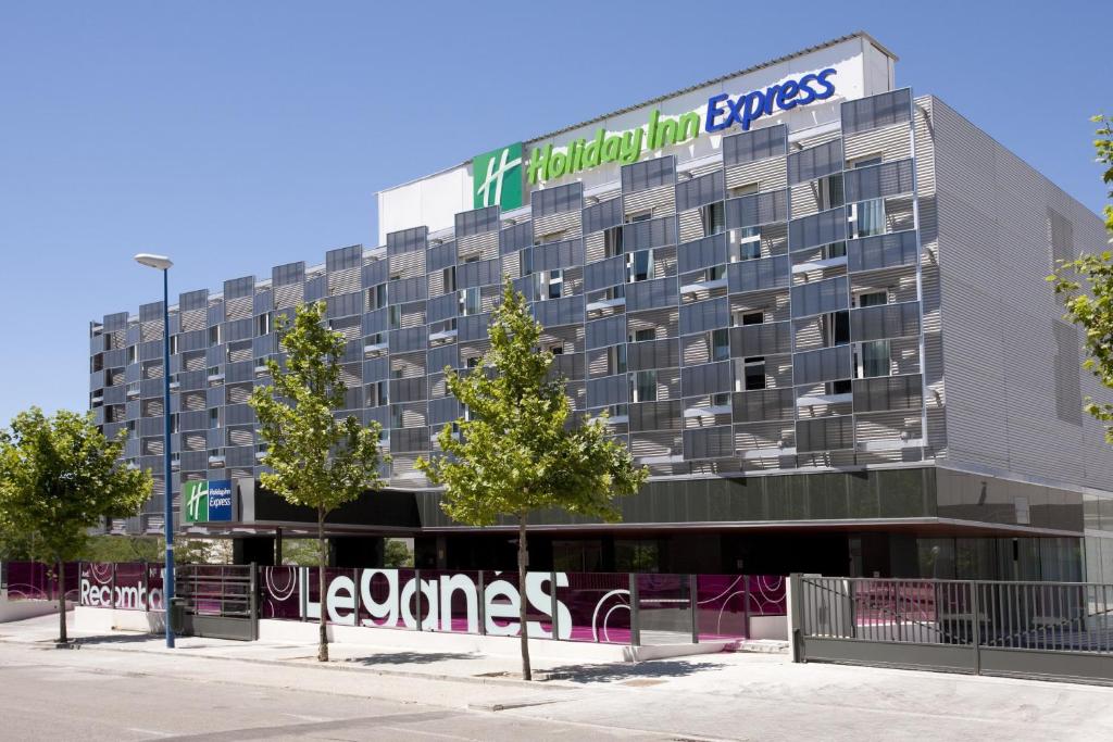 budynek z znakiem na boku w obiekcie Holiday Inn Express Madrid Leganes, an IHG Hotel w mieście Leganés