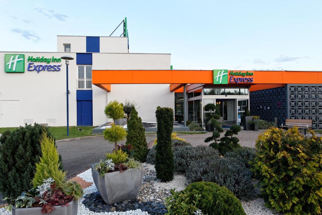 a store front with plants in front of it at Holiday Inn Express Strasbourg - Sud, an IHG Hotel in Geispolsheim