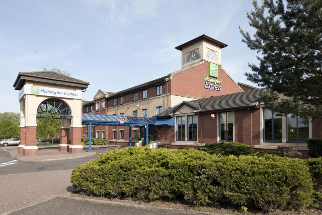a building with a clock tower on top of it at Holiday Inn Express Strathclyde Park M74, Jct 5 by IHG in Motherwell