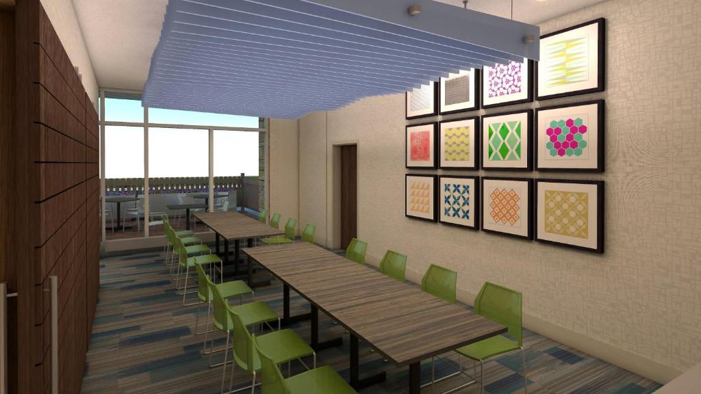 a dining room with wooden tables and green chairs at Holiday Inn Express - Nashville South - Spring Hill, an IHG Hotel in Spring Hill