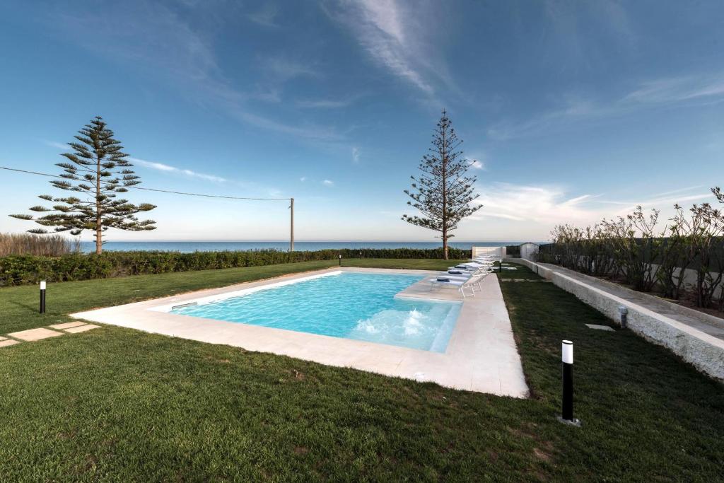 una piscina in mezzo a un prato di Sea Home - IsulaTravel a Marina di Modica