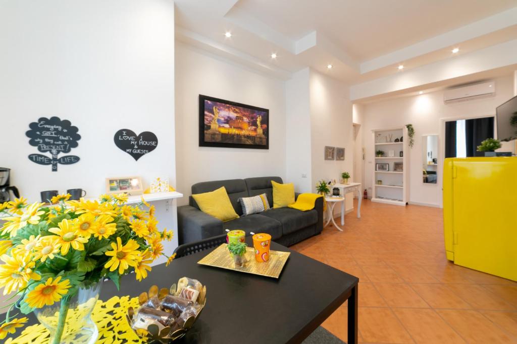 ein Wohnzimmer mit einem Sofa und einem Tisch mit gelben Kissen in der Unterkunft *****AmoRhome***** New Luxury apartment in the heart of Rome in Rom