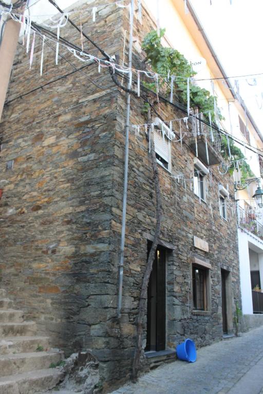 un antiguo edificio de ladrillo con escaleras en una calle en Casa do Sapateiro, en Sobral de São Miguel