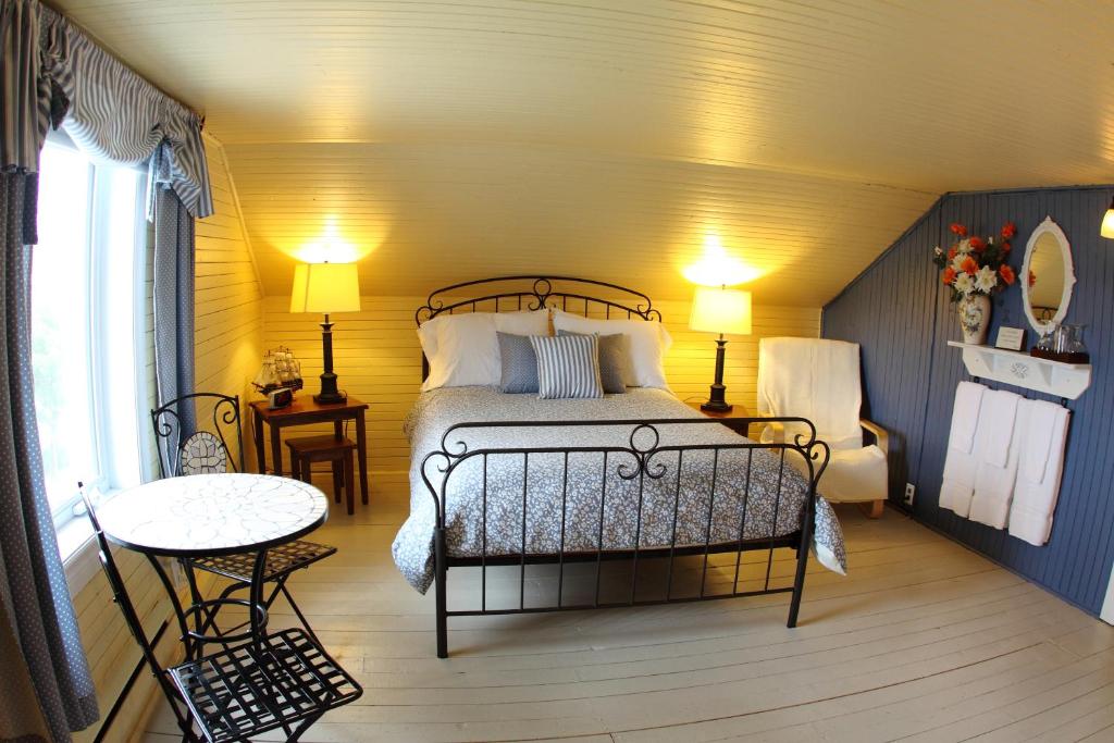 - une chambre avec un lit, deux tables et deux lampes dans l'établissement La Grange aux Hiboux Gîte et Restaurant B&B, à La Baie