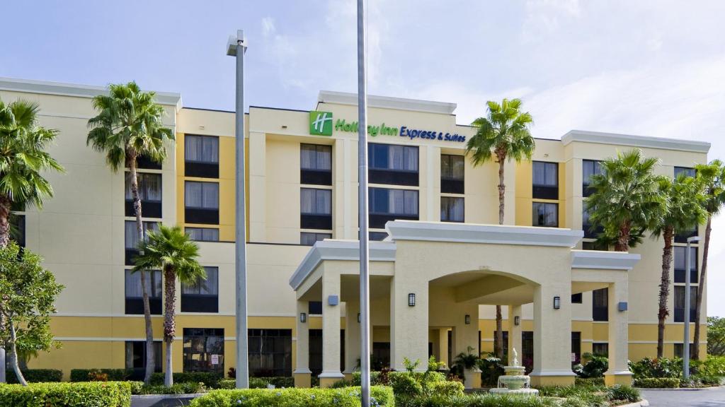 Holiday Inn Express Hotel & Suites Kendall East-Miami, an IHG Hotel في كيندال: مبنى مكتب أمامه أشجار نخيل