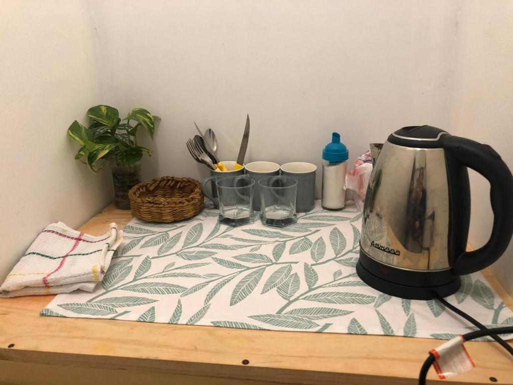 a tea kettle sitting on a table with glasses on it at Alojamiento Alelí in Posadas