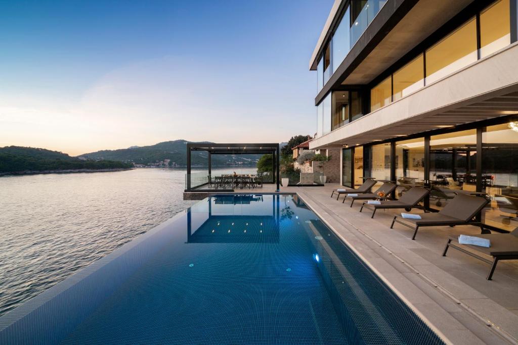 a swimming pool on the side of a building next to the water at Villa Amelie - Private Seaside Haven in Dubrovnik